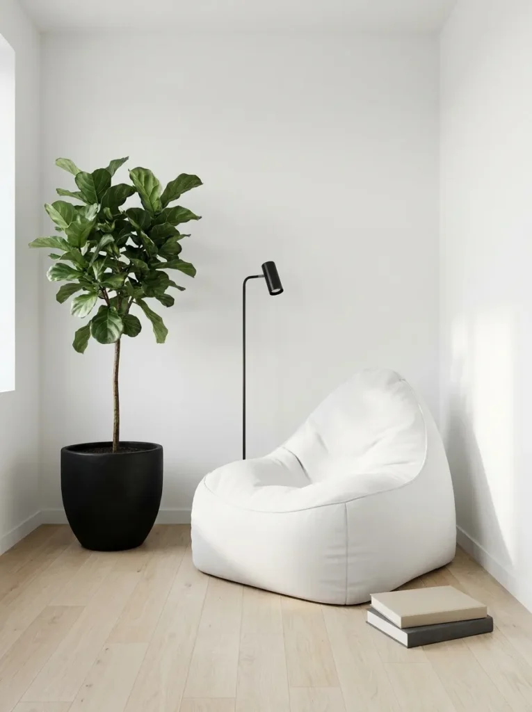 Minimalist reading nook with one matte white bean bag chair, one tall fiddle leaf fig in matte black ceramic pot, slim black floor lamp, two hardcover books stacked on pale oak floor, white wall, soft natural daylight, generous negative space, photorealistic, clean modern interior photography, 2:3 vertical"