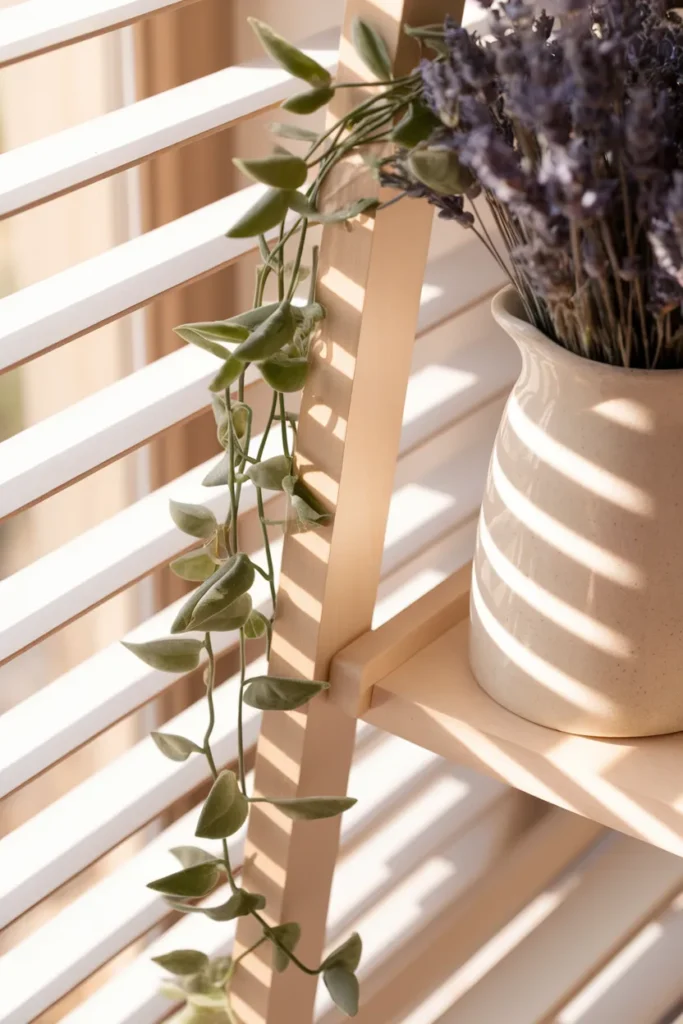 Trailing pothos and dried lavender on a ladder shelf in a small cottagecore apartment.