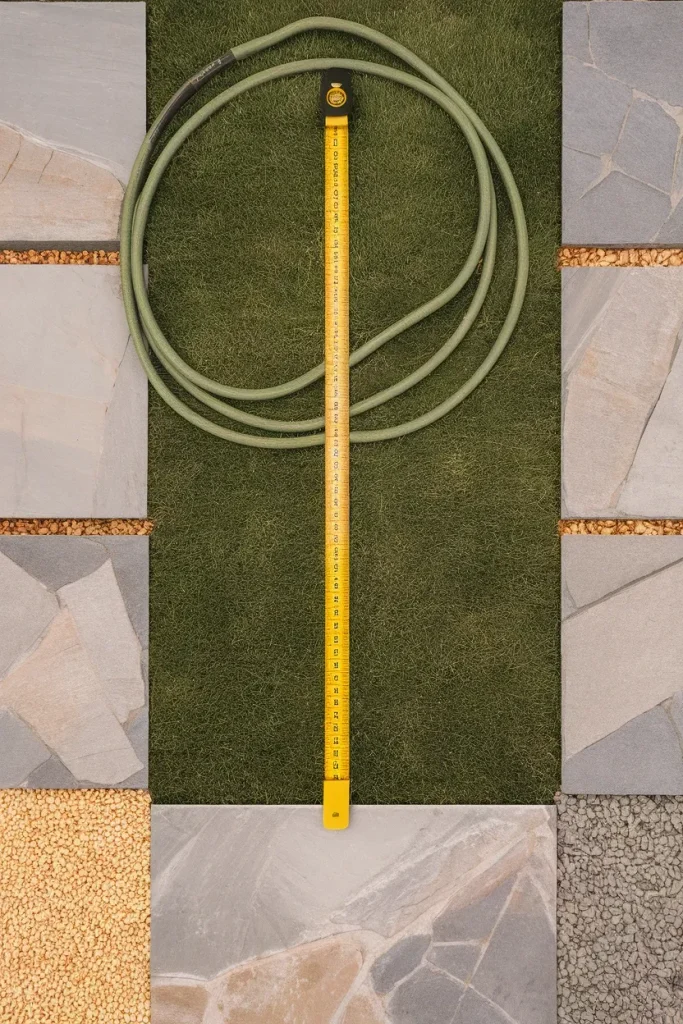 Tape measure across lawn showing a 36 inch garden path width with flagstone samples.