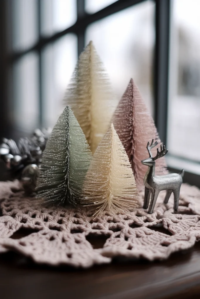Vintage bottle brush trees on a crocheted doily with a tin reindeer for cottagecore christmas decor.