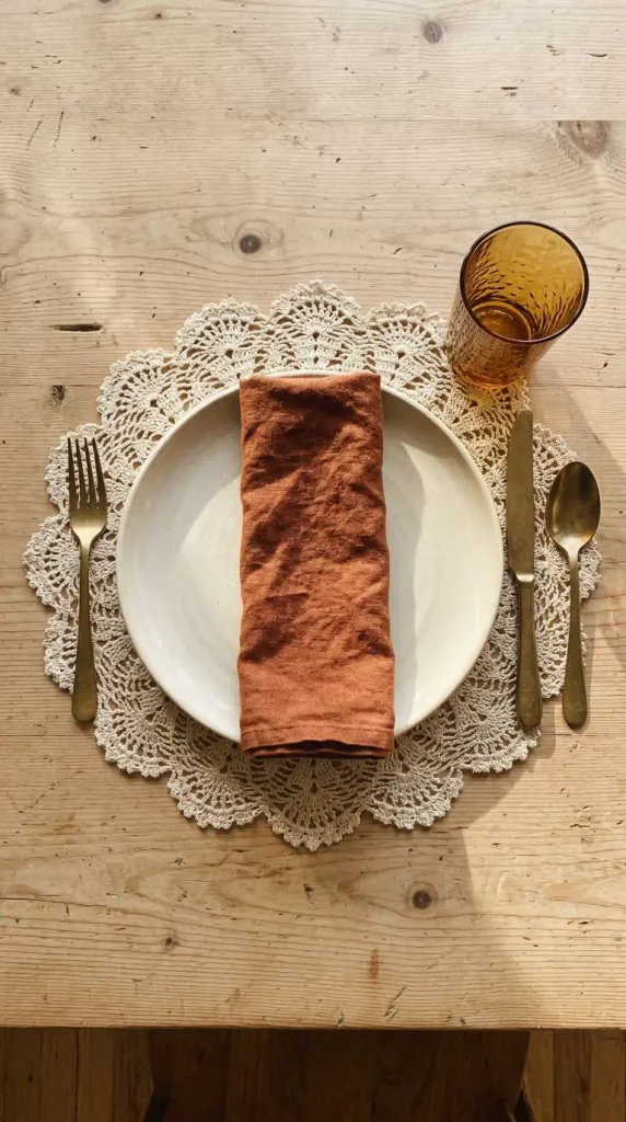 Lace doily under a dinner plate in place of a charger in a small Thanksgiving place setting