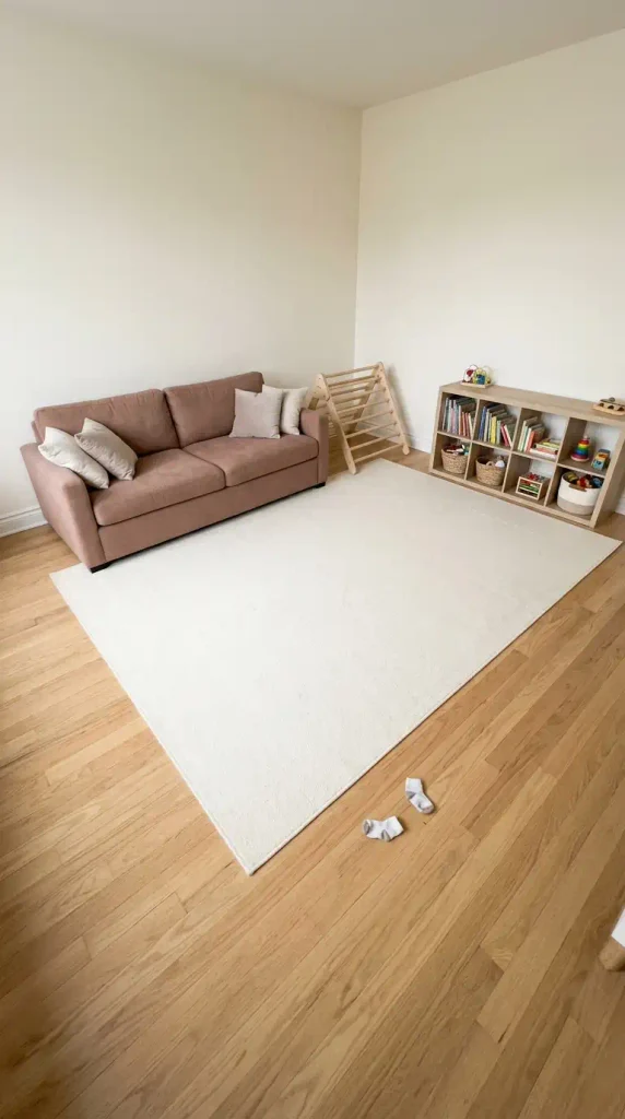 Small Montessori playroom corner with furniture against the walls and an open rug for movement