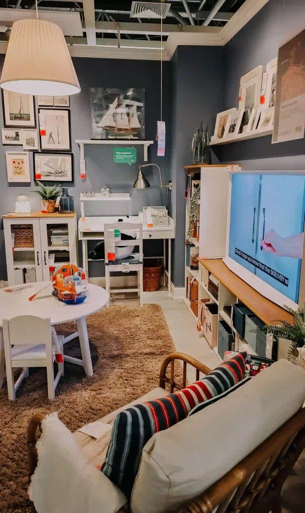 An organized showroom setup displaying a small-space family living area with dark blue walls